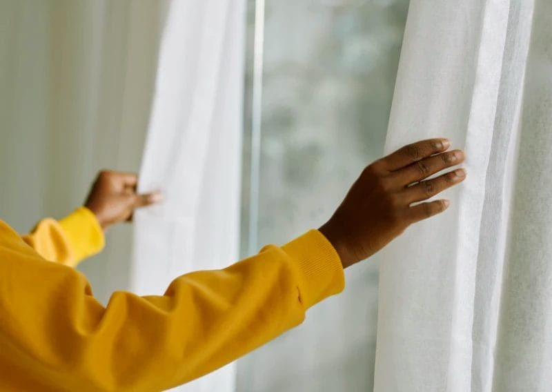 Person opening made-to-measure curtains