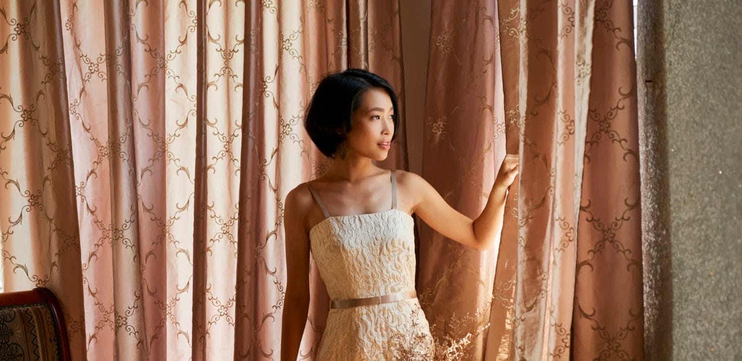 lady looking out of her made to measure curtains